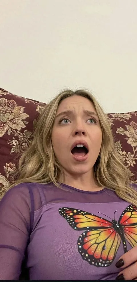 Blonde fictional AI character relaxing on a sofa